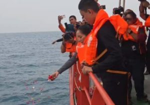Prosesi tabur bunga dari atas kapal KN SAR Tetuka oleh tim penyelamat dan perwakilan jurnalis dengan mengenakan pelampung oranye di laut Selat Sunda Banten.