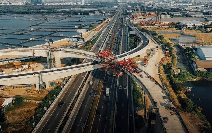 Foto udara proyek konstruksi jembatan layang simpang susun interchange Jalan Tol Kataraja Kamal Teluknaga Rajeg PIK 2